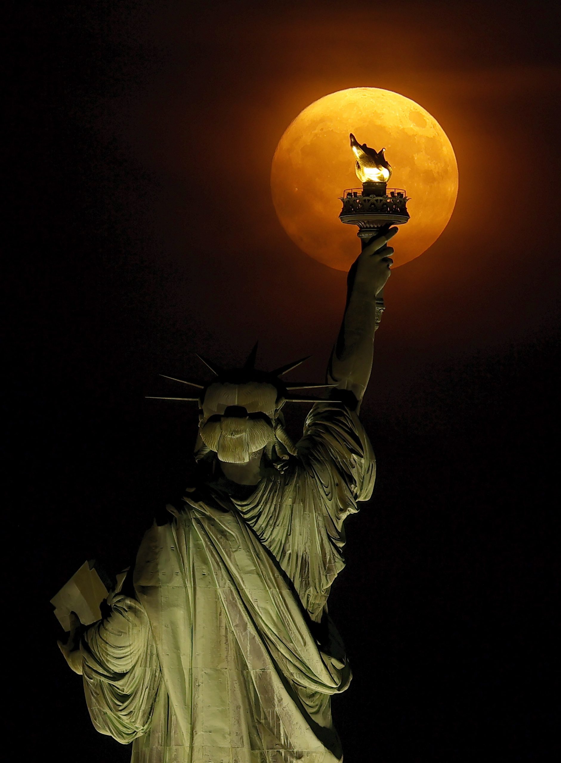 A New York-i Szabadság-szobor fáklyája mögött látványos módon kelt fel a Hold a minap. (Kép: Gary Hershorn/Getty Images)