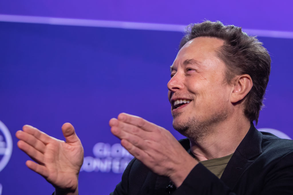 Elon Musk egy 2024-es konferencián magyaráz éppen, legújabb elképzelése szerint a világ összes bajba került emberén segítene. (Fotó: Apu Gomes/Getty Images)