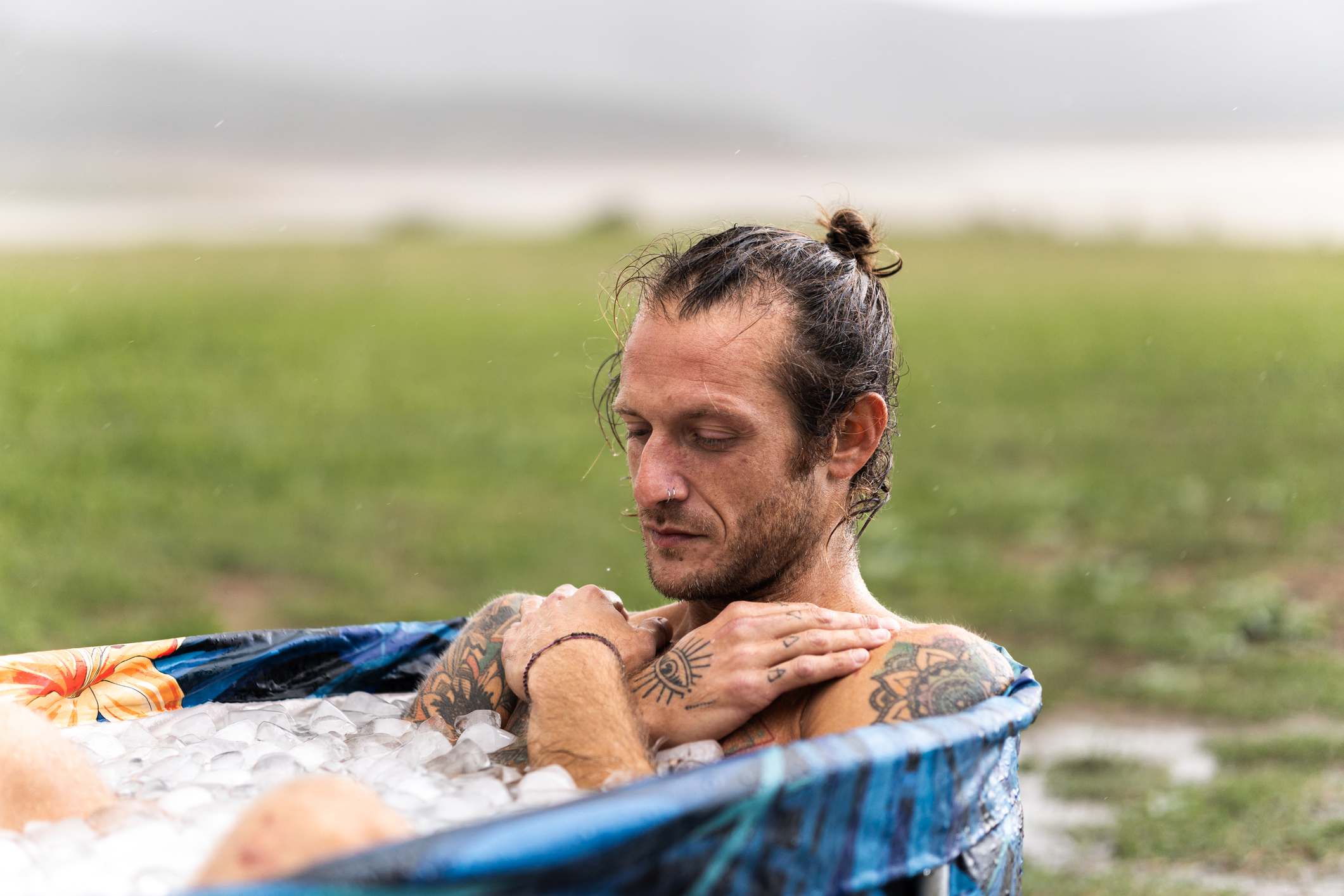 Athlete relaxing in a portable ice bath outside after a workout session, embracing the benefits of cold therapy